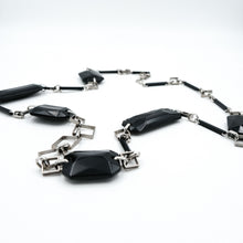 Carica l'immagine nel visualizzatore di Gallery, Collana in bachelite nera, anni 80. Gli elementi in bachelite sono alternati ad anelli in metallo argentato a forma di rombo. In vendita presso La Fiera di Sinigaglia. - Black bakelite necklace , 1980s. The Bakelite elements are alternated with rhombus-shaped silver metal rings. For sale at la Fiera di Sinigaglia.