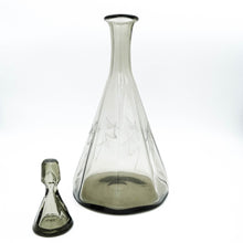 Carica l'immagine nel visualizzatore di Gallery, Servizio di bicchieri anni 30 in vetro fumè di forma ottagonale completo per sei persone, composto da cinque bicchieri per ogni posto tavola e due bottiglie per il vino. Particolare di una delle due bottiglie da vino in vendita presso La Fiera di Sinigaglia. - Complete set of 1930s octagonal smoked glass glasses for six people, consisting of five glasses for each table setting and two bottles for wine. Detail of one of the two wine bottle for sale at La Fiera di Sinigaglia.