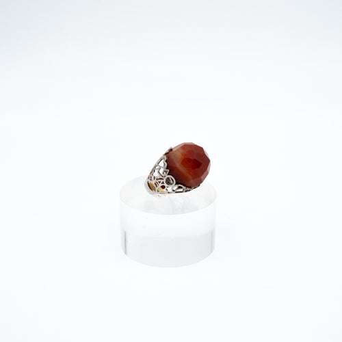 Anello con grande corniola sfaccettata e argento , anni '80. Misura 18, regolabile su richiesta. Particolare della montatura traforata.- Ring with large faceted carnelian and silver, 1980s. Size 18, adjustable on request. Detail of the perforated frame